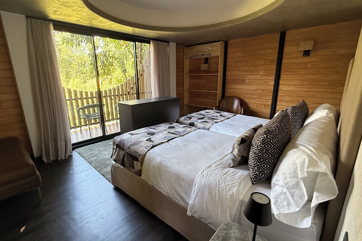 Un dormitorio moderno con una cama grande, un escritorio y vistas al exterior.