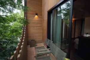 Pared exterior de madera con un banco, una planta en maceta y una ventana.