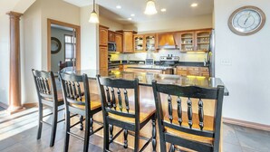 Une cuisine moderne avec des meubles en bois, un îlot central et des luminaires suspendus.