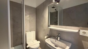 A modern bathroom with a shower, toilet, and sink. - Beachfront studio in Scharbeutz - comfort & tranquillity right by the sea (Scharbeutz)