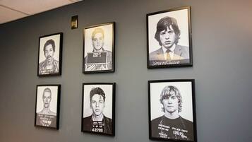 Six framed mugshots on a wall.