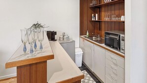 Cuina amb microones, rentamicroplates, armaris i taulell amb vetrería.