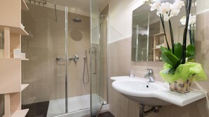 A modern bathroom with a glass-enclosed shower, a white sink, and a mirror. - Amazing Duomo loft with terrace and elevator (Florence)