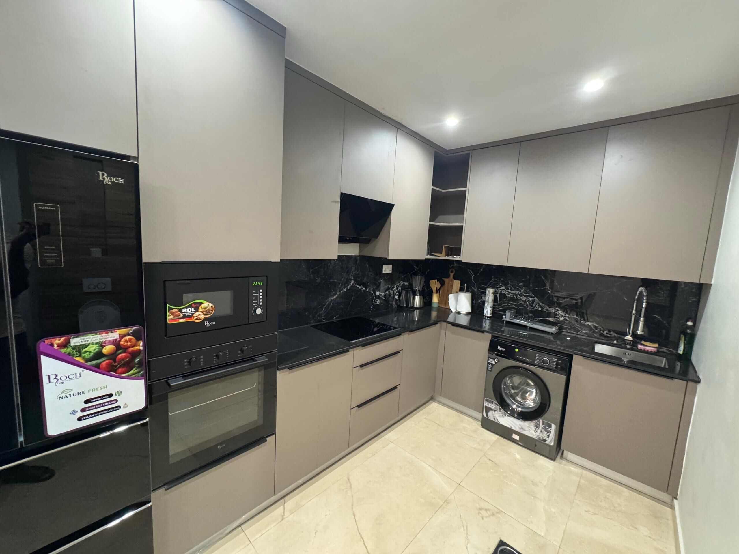 Een moderne keuken met een Bosch koelkast, oven, magnetron en wasmachine.