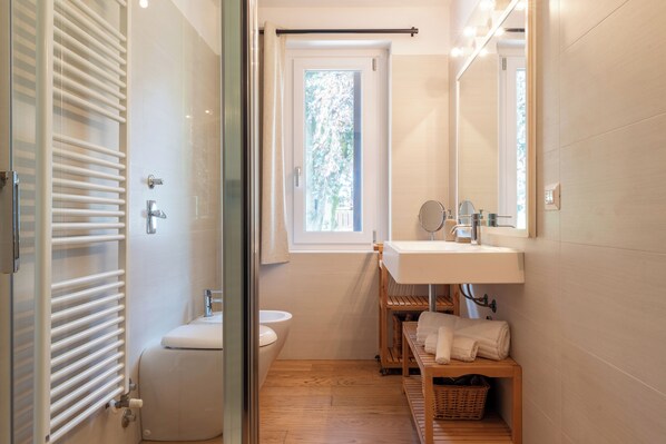 A compact bathroom with a toilet, sink, and a window.