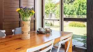 Ein Holzespeisekammer mit Stühlen, einer Blumenvase und einer Uhr an der Wand.
