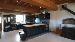 A modern kitchen with dark cabinetry, a wooden countertop, and a built-in oven.