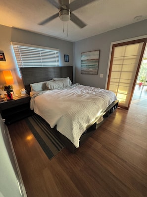 A modern bedroom with a bed, bedside table, lamp, and a ceiling fan. - Monthly rental  lap pool 40 ft dock wDavitz (Big Pine Key)