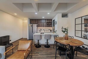 Cocina moderna con una isla central, taburetes de bar y una mesa de comedor con individuales tejidos.