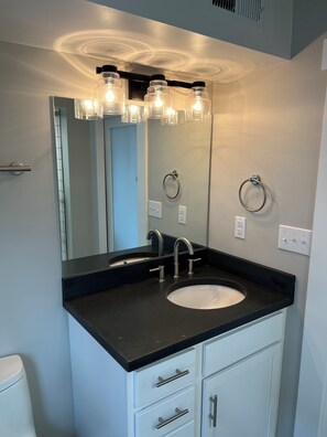 Een douche, handdoeken, zeep, shampoo