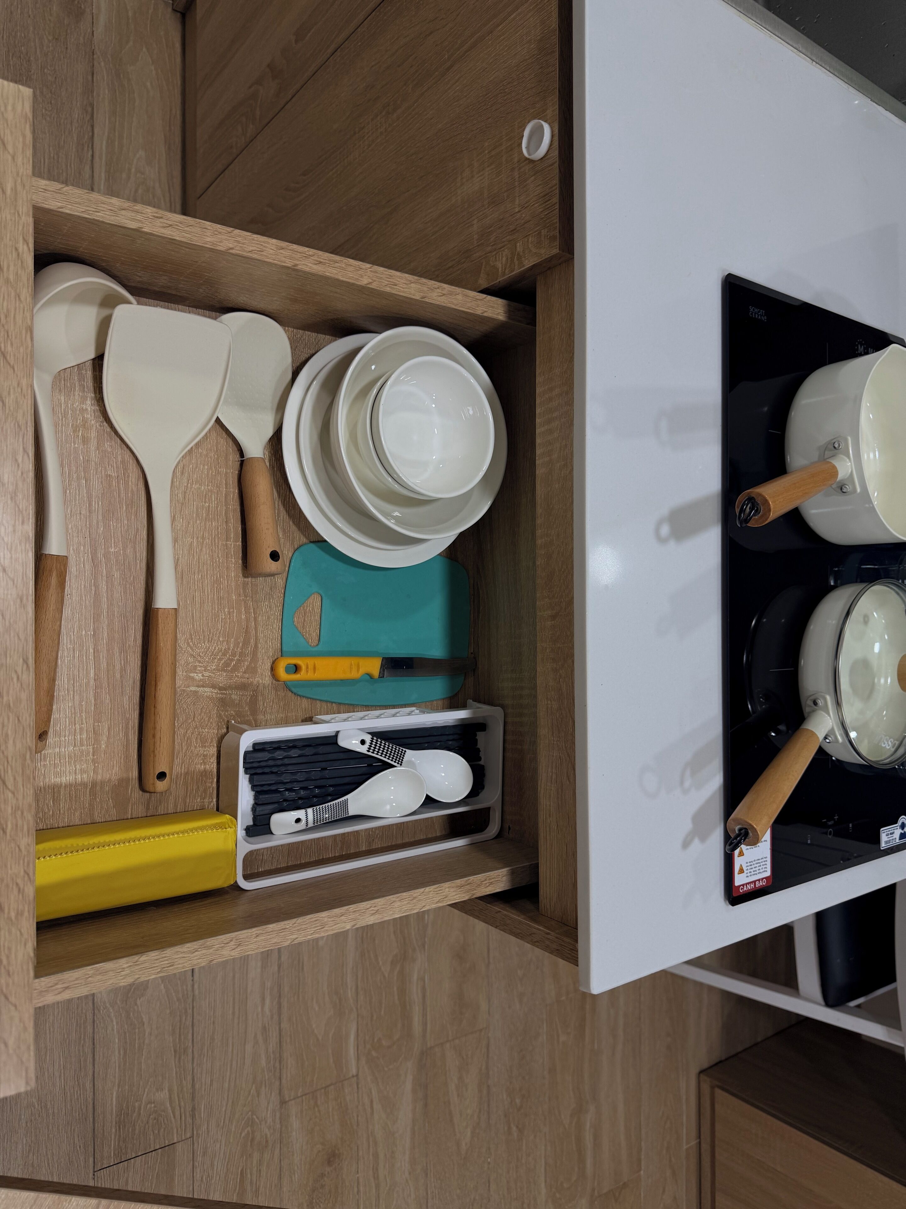 A kitchen with wooden cabinets, a white stove, and various kitchen utensils.