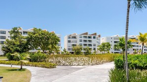 A modern hotel with multiple white buildings, a central pathway, and surrounding greenery. - Tropical Escape! Breezy Lagoon + Pool Views (Punta Cana)