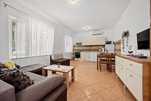 Un salon moderne avec un canapé, une petite table et un téléviseur.