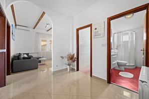 Une chambre d’hôtel comprenant un espace de vie, une salle de bain et un couloir.