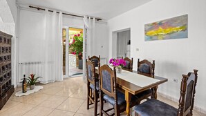 A dining area with a table, chairs, and a vase of flowers. - Four Bedroom Apt. near the Beach - Villa Jagoda (Kampor)