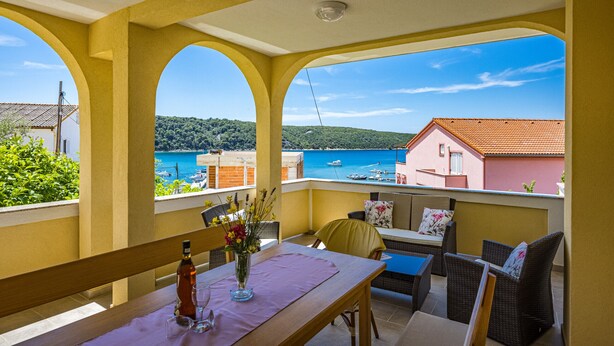 A balcony with a table, chairs, and a bottle of wine. - Four Bedroom Apt. near the Beach - Villa Jagoda (Kampor)