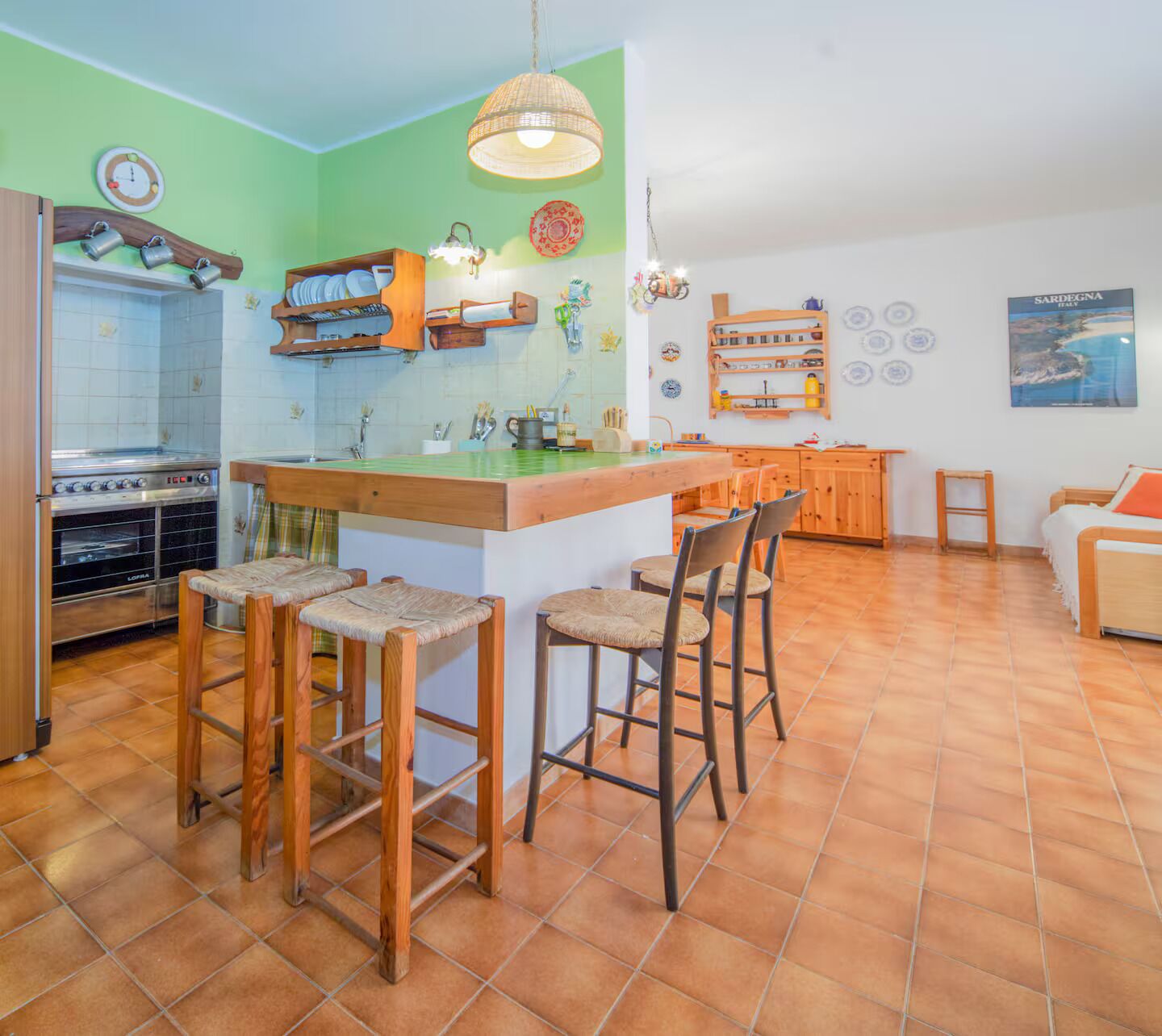 Une cuisine dotée d’un îlot central, de tabourets de bar, d’une cuisinière et d’un réfrigérateur.