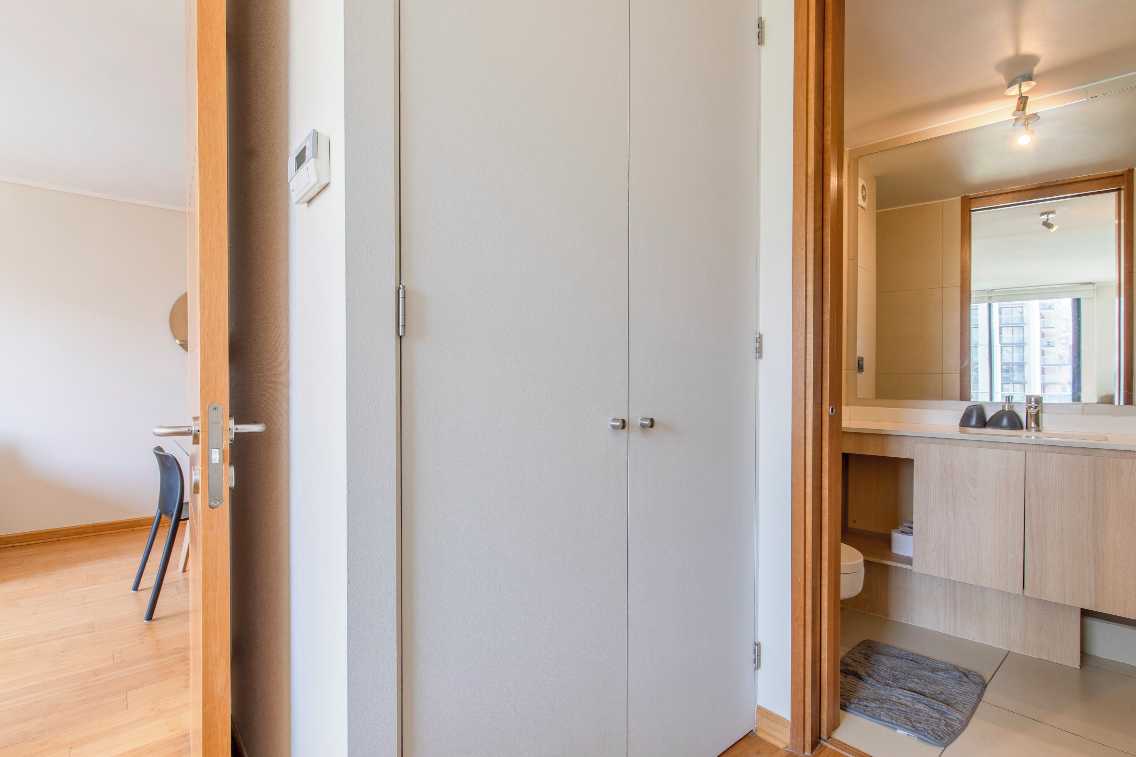 Une salle de bain moderne avec un grand miroir, des toilettes et un lavabo.