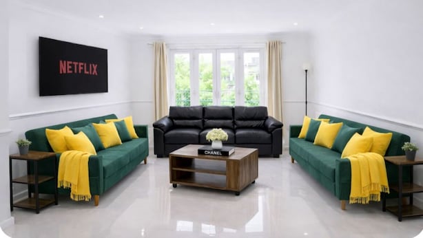 A modern living room with two green sofas, a wooden coffee table, and a black leather sofa. A large TV screen displays the Netflix logo. - Stylist 7sleeps contractor groups friendly1bedroom flat Canada Water free WiFi (London)
