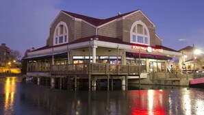 A waterfront building with a balcony, a sign for 'Broadwalk Blues,' and a reflection on the water. - Cypress Bend @ Barefoot - Updated w/ Pools, Golf, Shuttle (North Myrtle Beach)