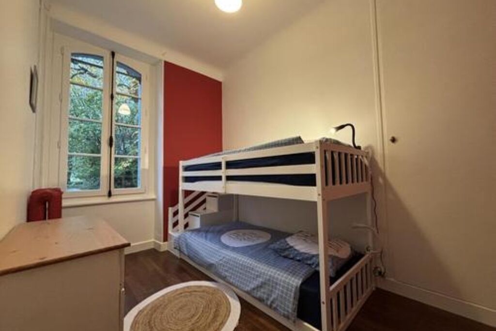 Dormitorio con literas, escritorio y ventana.