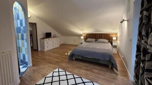 Ein Schlafzimmer mit einem großen Bett, einem Schminktisch und einem Nachttisch.