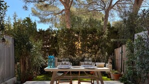 Un ensemble de mobilier de patio comprenant une table à manger, des chaises, un banc et un panier décoratif.