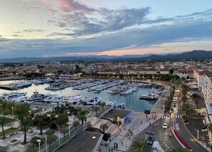 A marina with numerous boats docked, surrounded by a cityscape with buildings and a clear sky. - New 250m Beach Apt with Pool & Terrace (Saint-Raphaël)