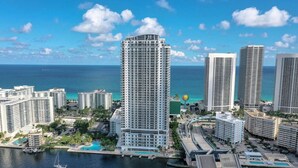 A high-rise hotel with a view of the ocean and a marina.
