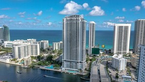A high-rise hotel with multiple floors, a marina, and a view of the ocean.