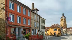 En gatubild med byggnader, inklusive en restaurang som heter ”BISTROT DES CLAQUETS”.