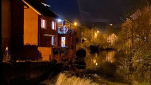 En byggnad med ett synligt vattenobjekt framför sig.