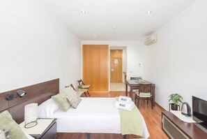 Une chambre d’hôtel comprenant un lit, une table de chevet, une télévision, un bureau et une chaise.