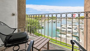 Un balcon donnant sur une marina, avec une chaise et une table.