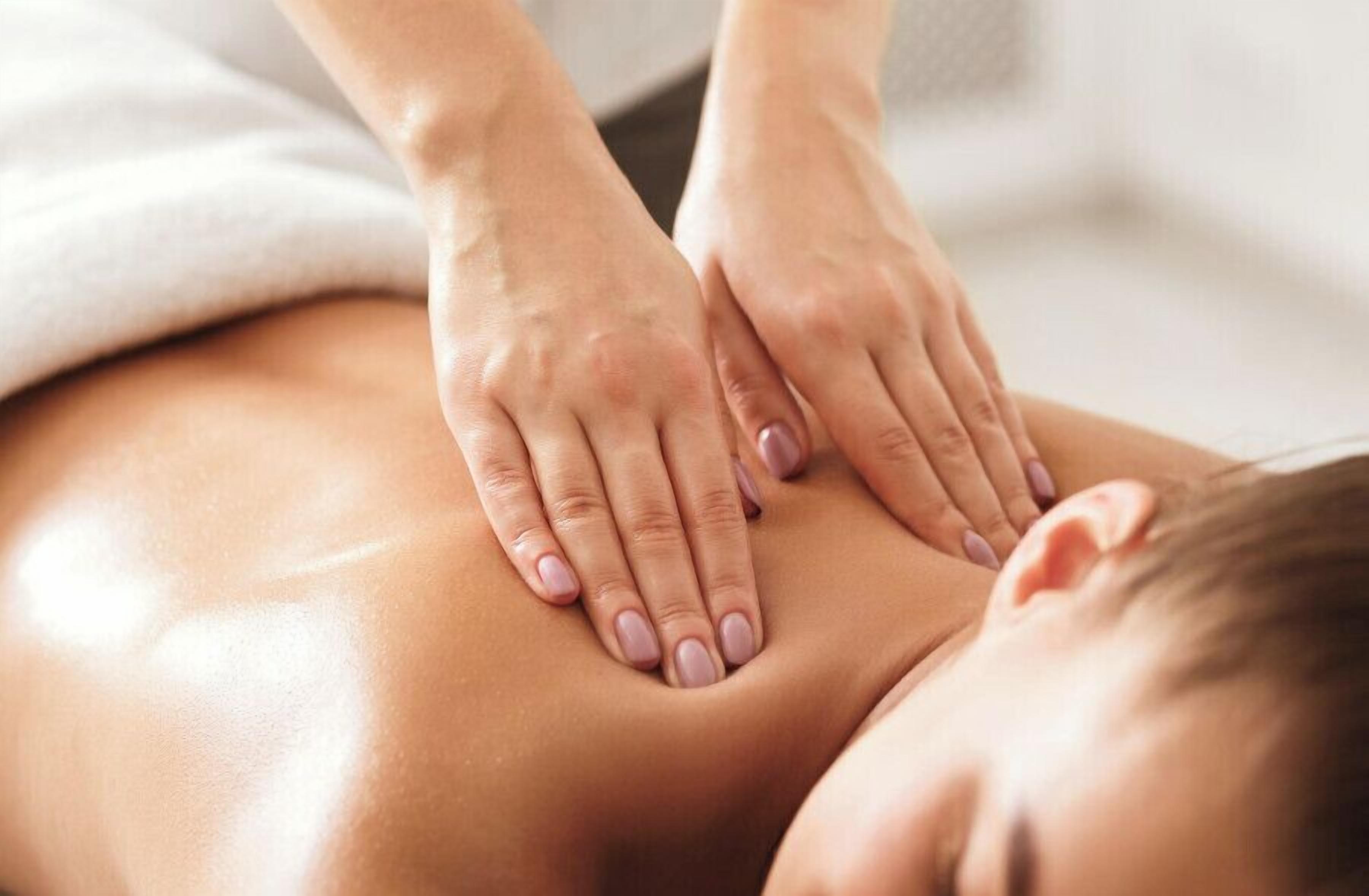 Sesión de terapia de masajes con manos sobre la espalda de una persona.