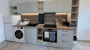Una cocina moderna con electrodomésticos integrados, armarios grises y una encimera de madera.