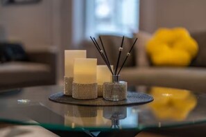 Une table en verre décorée de bougies et de diffuseurs de parfum à bâtonnets.