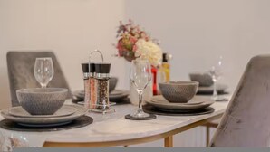 A dining table set with plates, bowls, glasses, and a salt and pepper shaker. - 3BR Putney Home London Sleeps 8 Winter Deal (London)