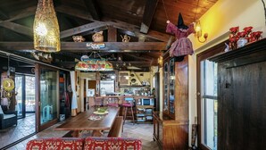 A cozy interior with a wooden dining table, benches, and a patterned sofa.