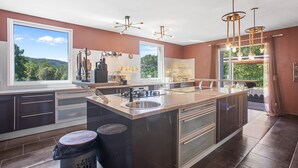 Una cucina moderna con una grande isola, elettrodomestici in acciaio inossidabile e luci a sospensione.