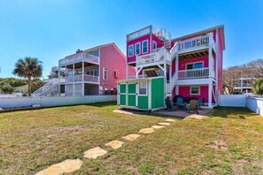 Ein mehrgeschossiges Haus mit Balkon und einem kleinen grünen Gartenhaus.