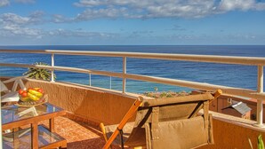 A balcony with a view of the ocean, a table with fruits, and a chair. - Your Island Villas Radazul (El Rosario)