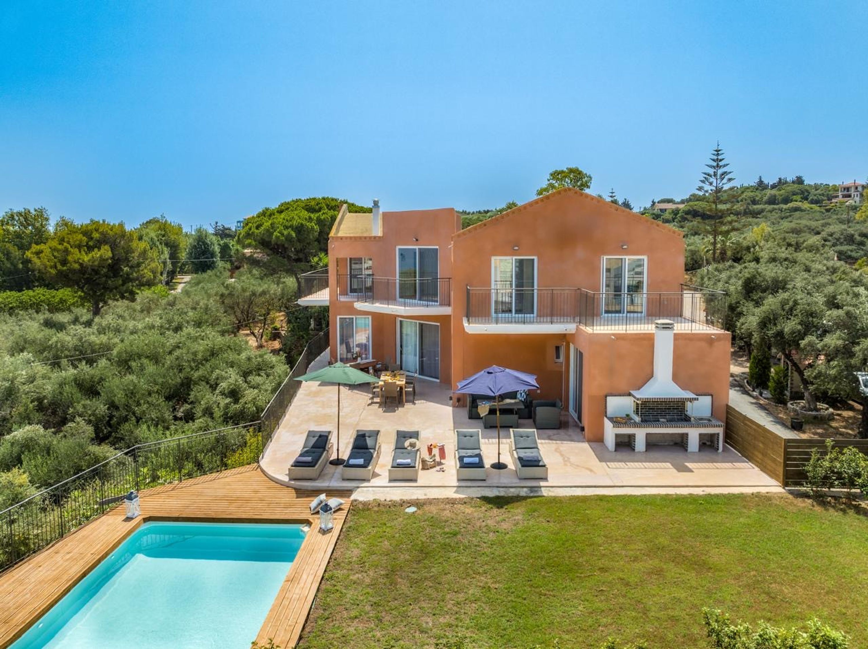 A two-story house with a swimming pool, outdoor seating, and a barbecue area.