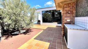 A modern house with a patio, a large window, and a brick wall. - Your Island Villas Mamma Mia 2 (Yaiza)