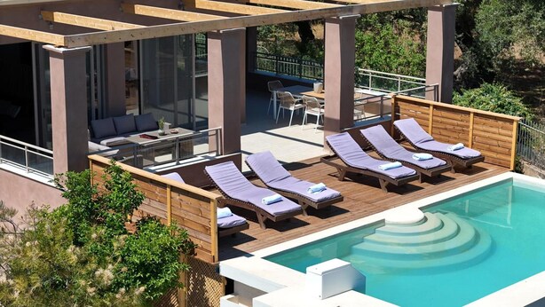 Area piscina sul tetto con poltrona relax e zona salotto.
