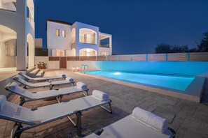 A modern pool area with lounge chairs and a swimming pool. - Villa Coral Blue in Planos (Zakynthos)