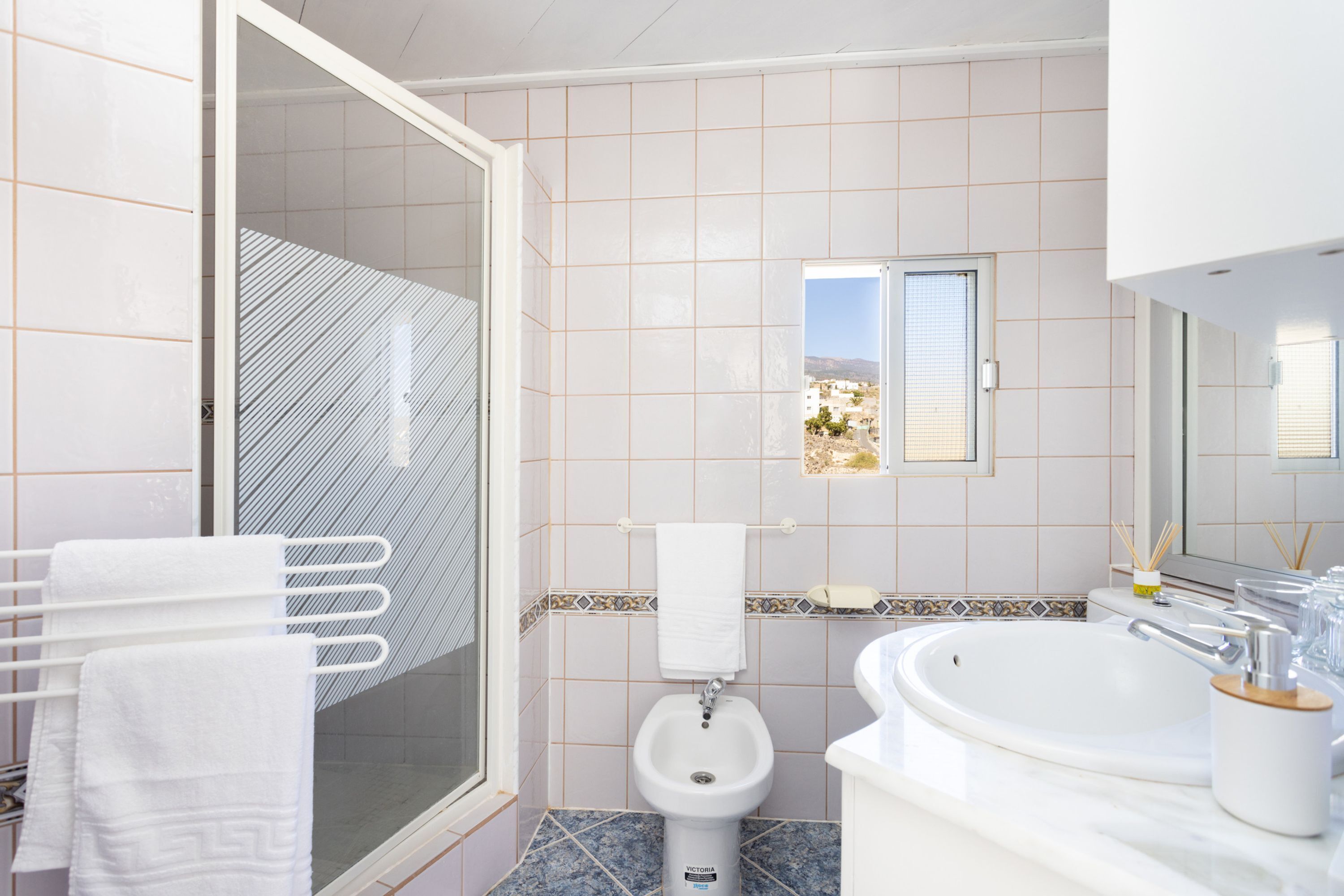 Een moderne badkamer met douche, toilet en wastafel.