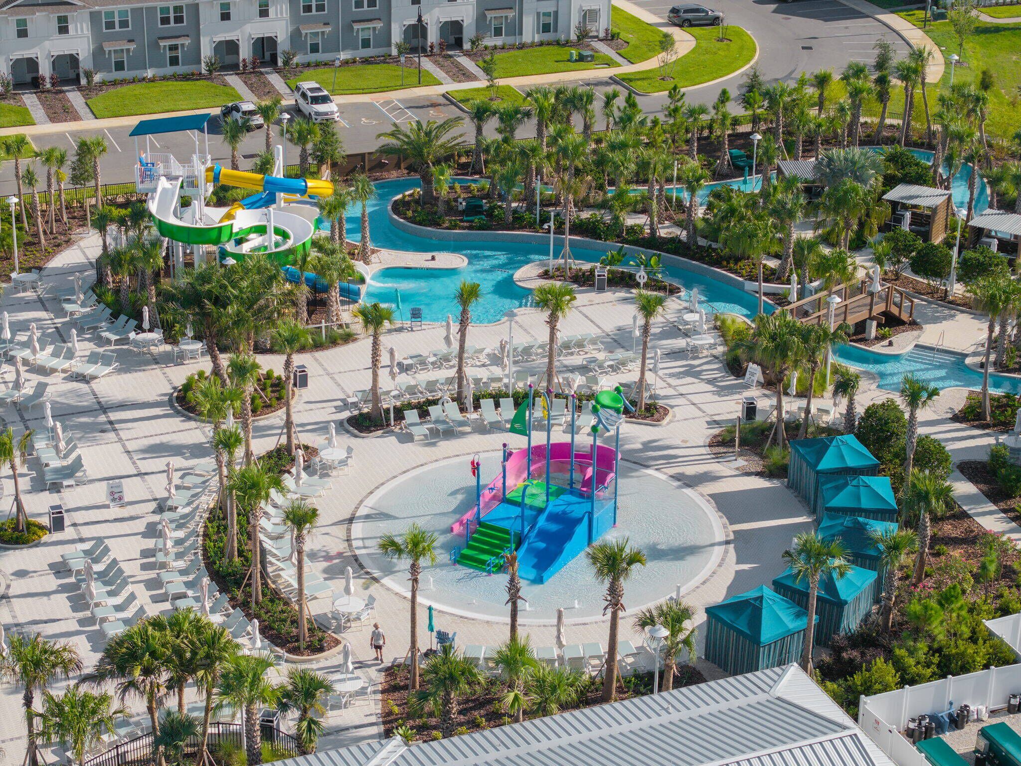 Ein Resort mit mehreren Schwimmbecken, einem Wasserpark und einer Auswahl an Liegestühlen und Sonnenschirmen.