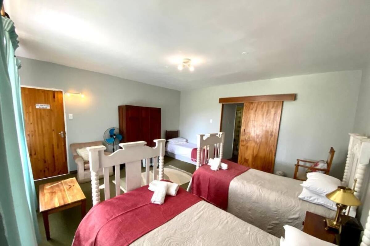 Une chambre d’hôtel avec deux lits, une armoire en bois, un bureau et une chaise.