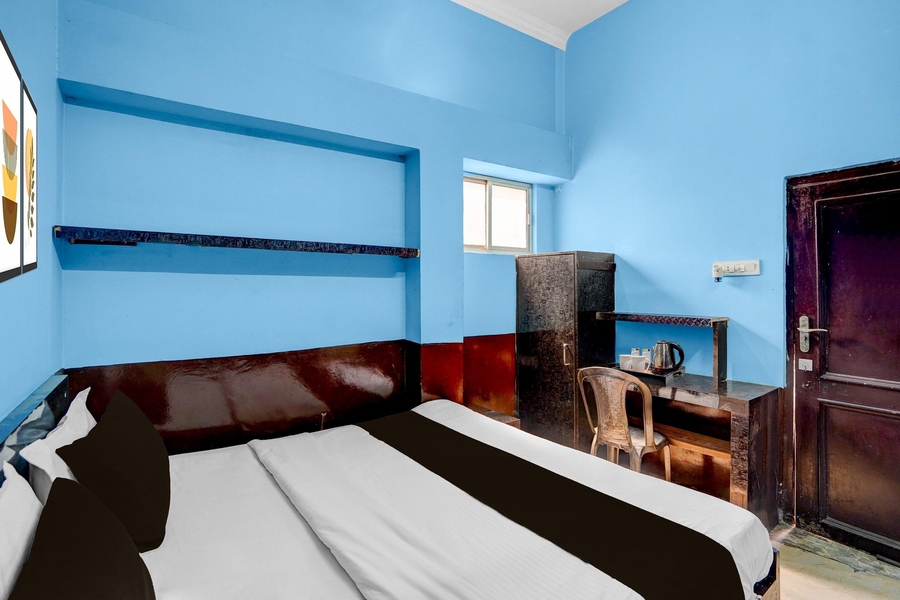 A room with a bed, a desk, a chair, and a wardrobe.